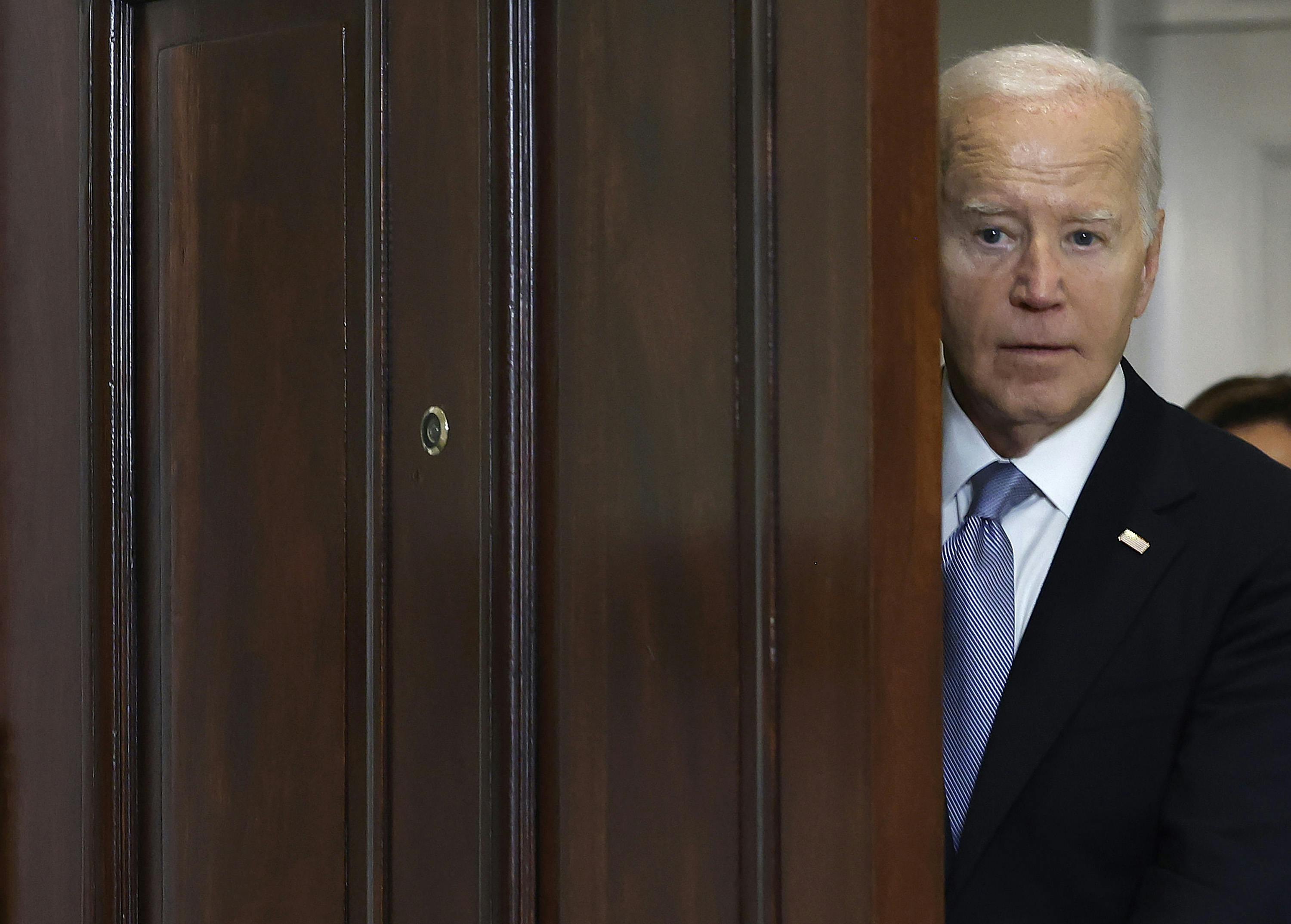 President Biden looks through a doorway