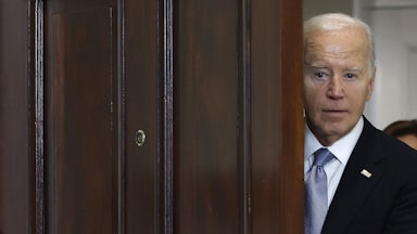 President Biden looks through a doorway