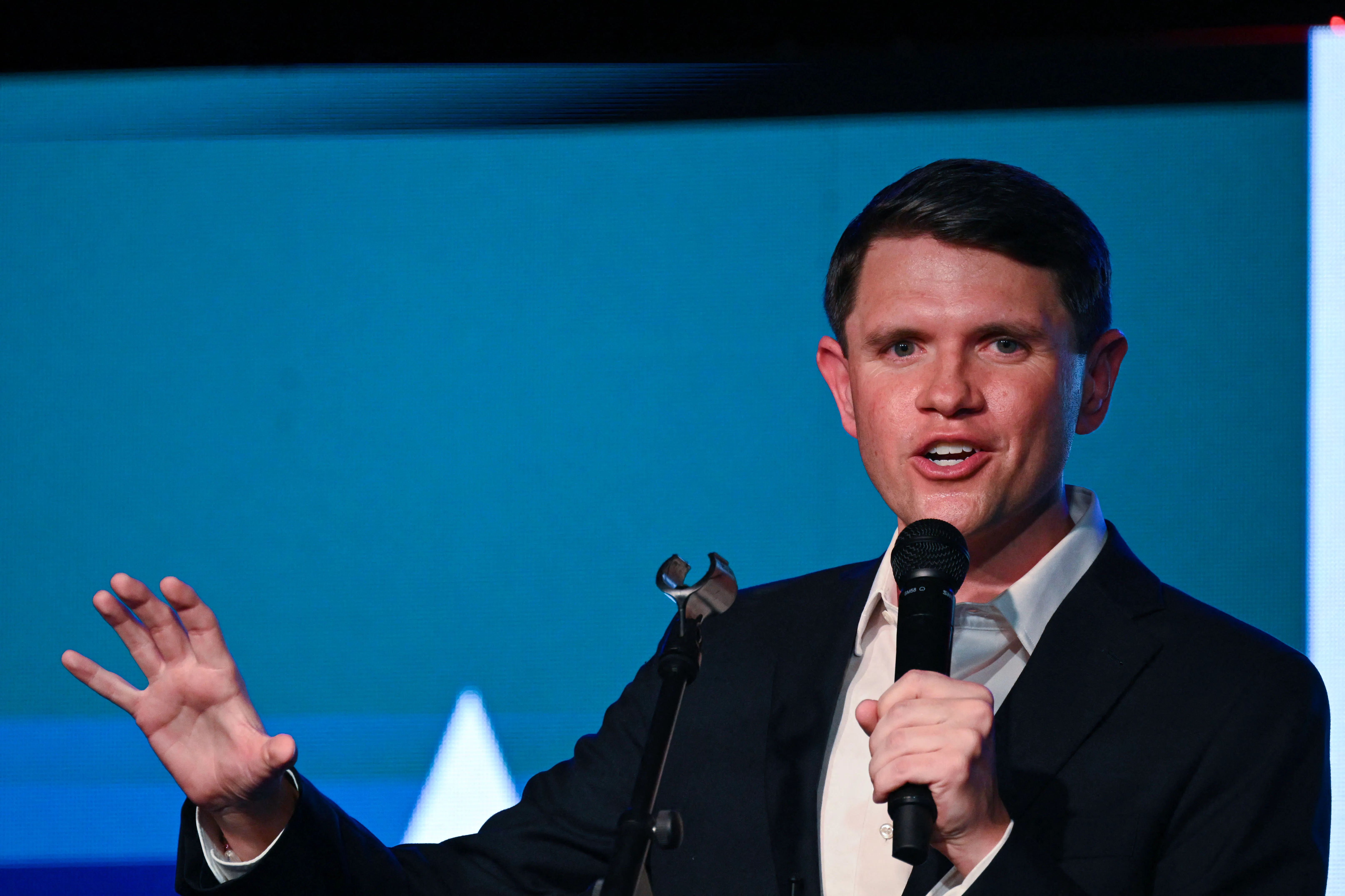 James Talarico gestures with one hand and speaks into a microphone he holds with the other
