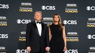 Donald and Melania Trump stand in front of a backdrop that reads "CBS" and "Kennedy Center Honors."