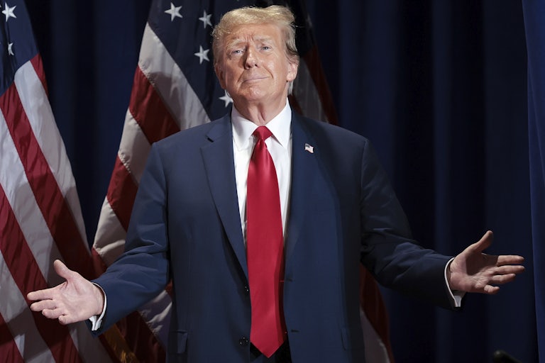 Donald Trump smiles and opens his arms as if presenting something