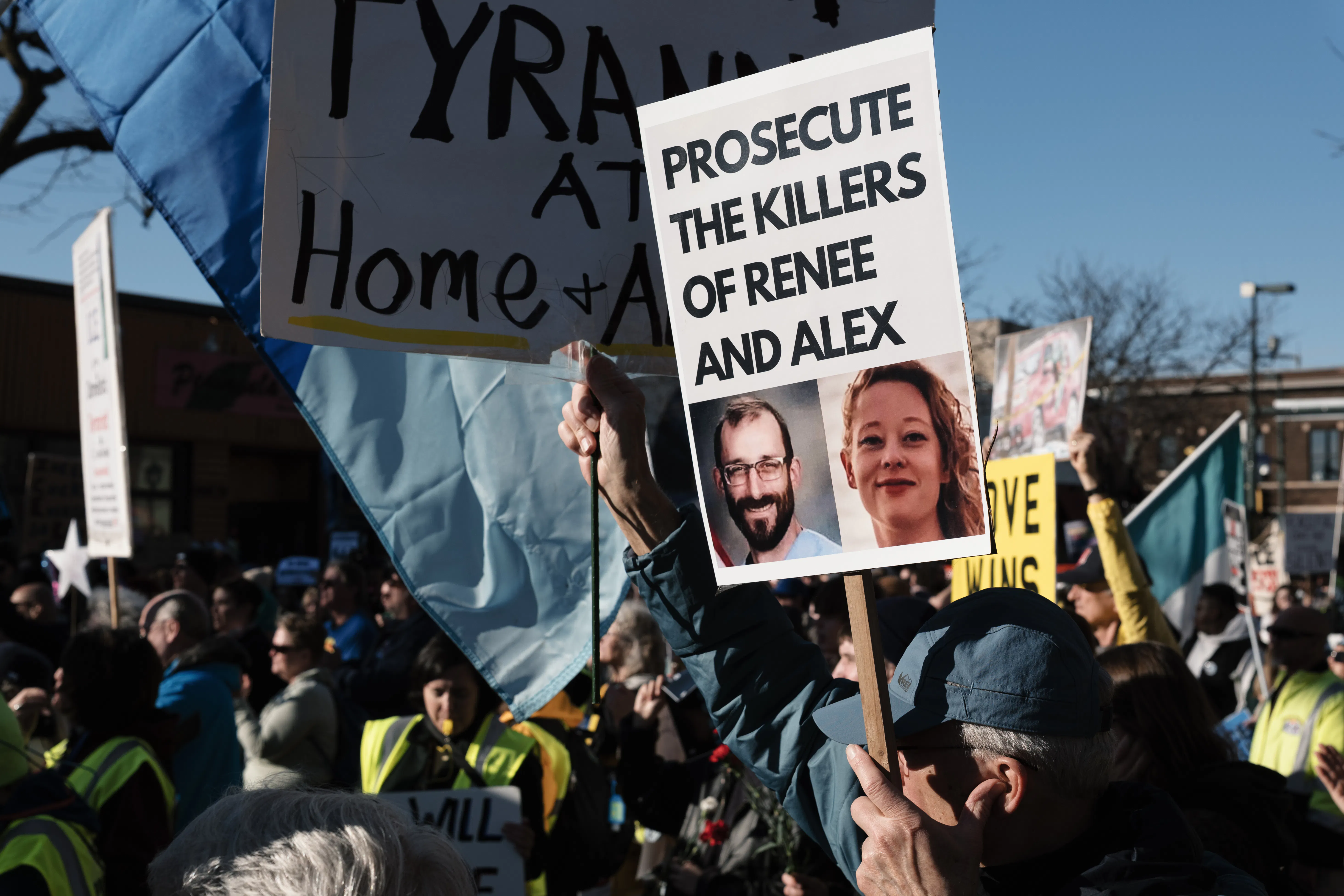 A person holds a sign that says, "Prosecute the killers of Renee and Alex," with photos of Renee Nicole Good and Alex Pretti, during an anti-ICE protest in Minneapolis, Minnesota.