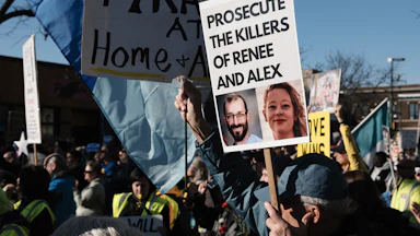 A person holds a sign that says, "Prosecute the killers of Renee and Alex," with photos of Renee Nicole Good and Alex Pretti, during an anti-ICE protest in Minneapolis, Minnesota.