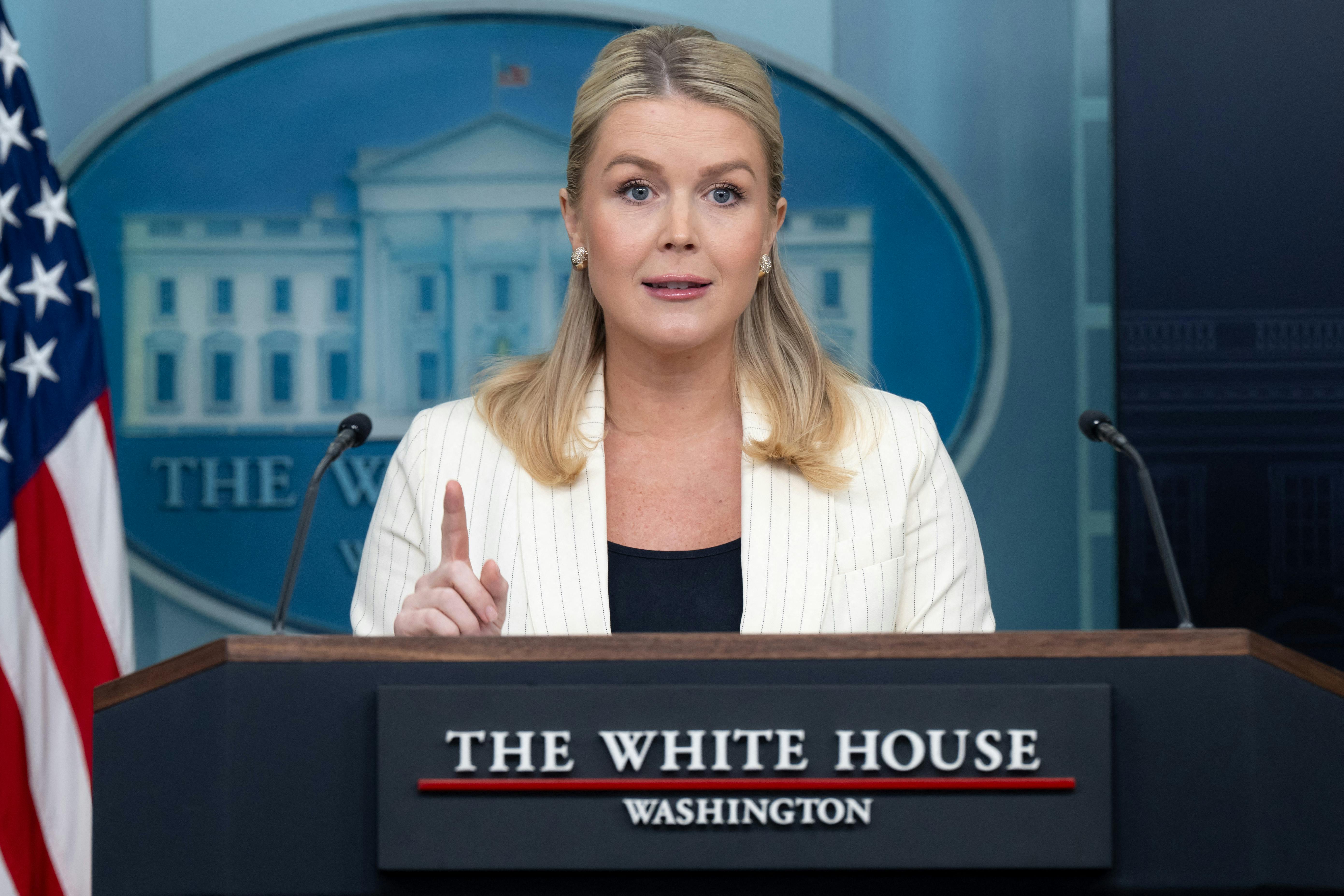 Karoline Leavitt raises a finger while speaking at the podium in the White House press briefing room