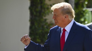 Donald Trump smiles to his right (off camera) and makes a victory fist