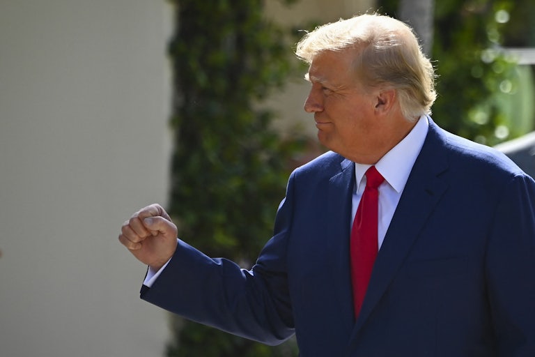 Donald Trump smiles to his right (off camera) and makes a victory fist