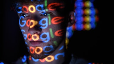 In this photo illustration, brightly colored Google logos are projected onto a man's face.