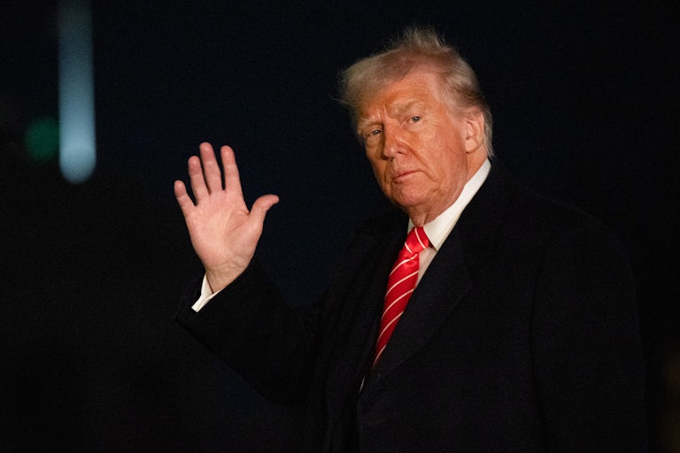 Donald Trump waves while walking outside the White House