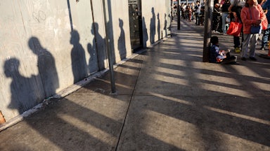 People wait in line on their way to cross the southern border into the United States near the San Ysidro Port of Entry in Tijuana, Mexico.