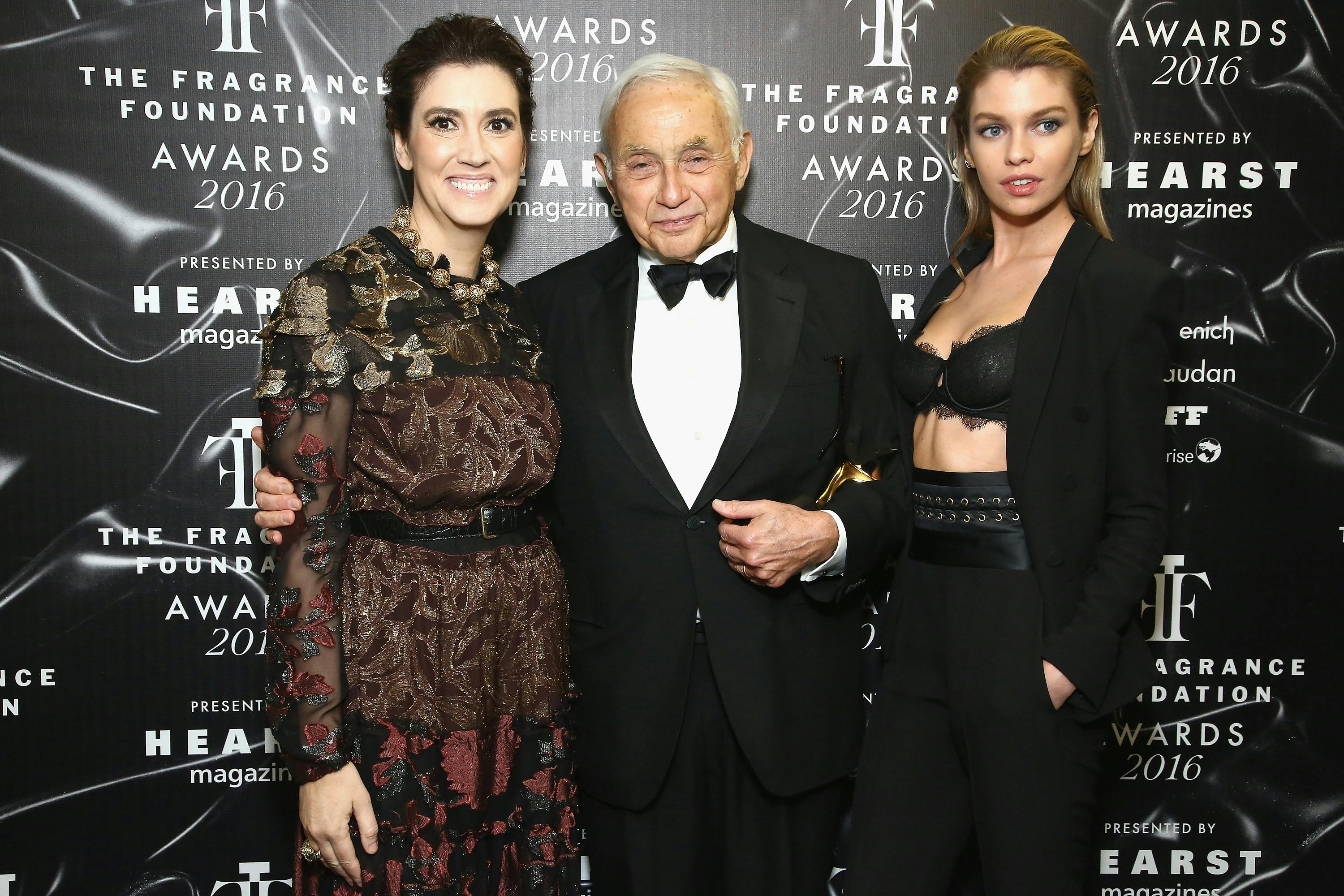 Elizabeth Musamanno, Les Wexner, and Stella Maxwell pose for the cameras in front of a backdrop.