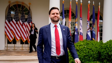 JD Vance strides outside the White House in front of some US flags