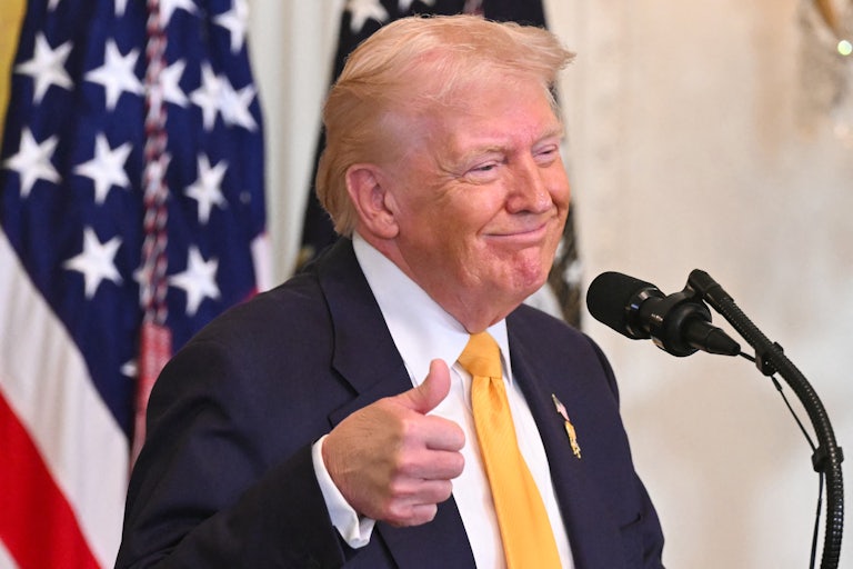 President Donald Trump gives a thumbs up as he speaks during a Black History Month event in the East Room of the White House.