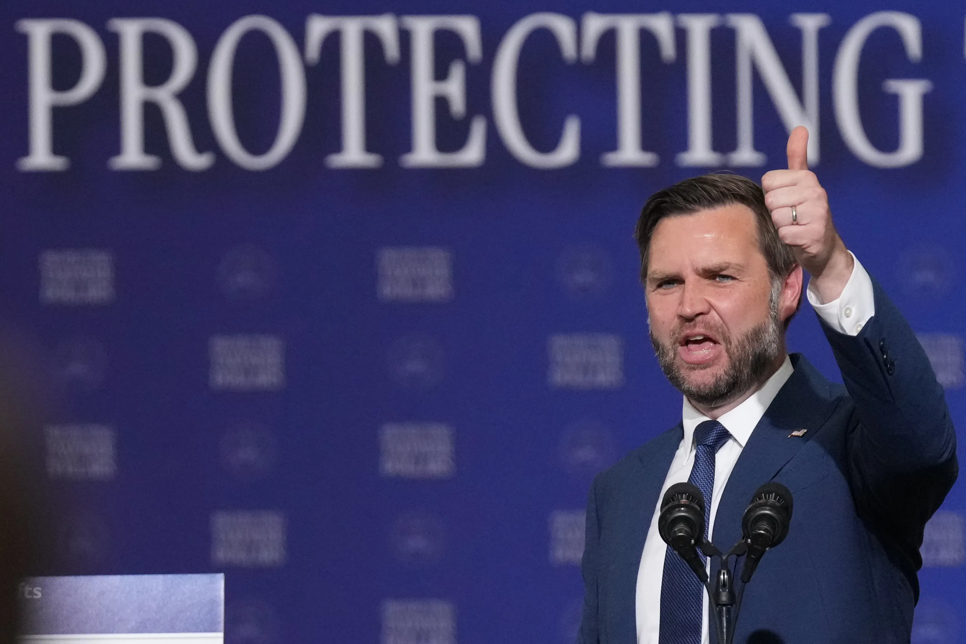 Vice President JD Vance gives a thumbs up while speaking at a microphone