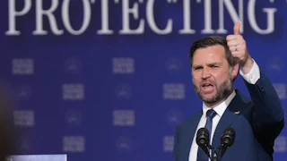 Vice President JD Vance gives a thumbs up while speaking at a microphone