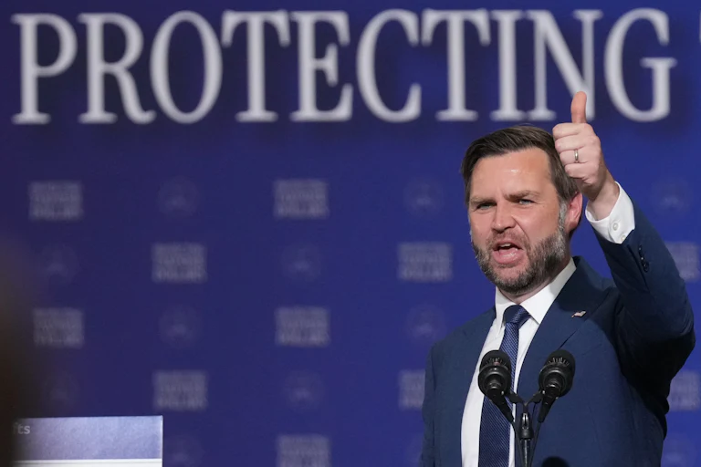 Vice President JD Vance gives a thumbs up while speaking at a microphone