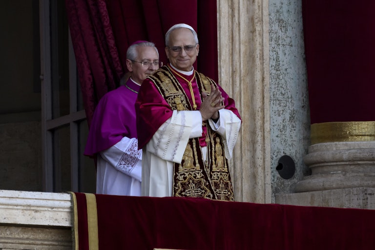 Pope Leo XIV waves while standing on the balcony of the Vatican