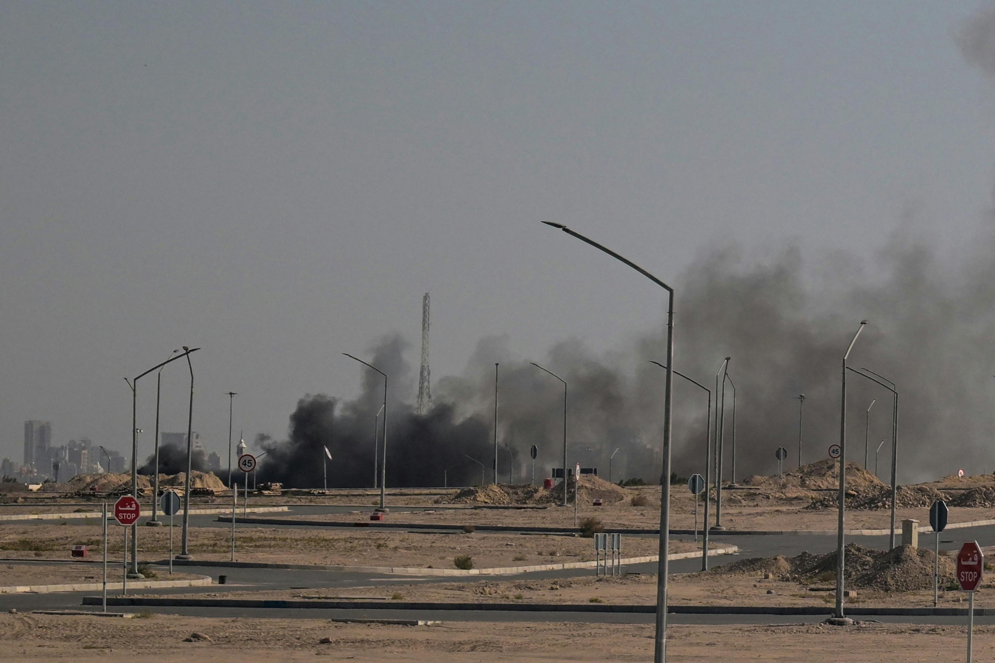 Smoke rises in the background in a photo in Kuwait City.