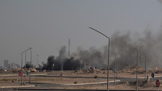 Smoke rises in the background in a photo in Kuwait City.