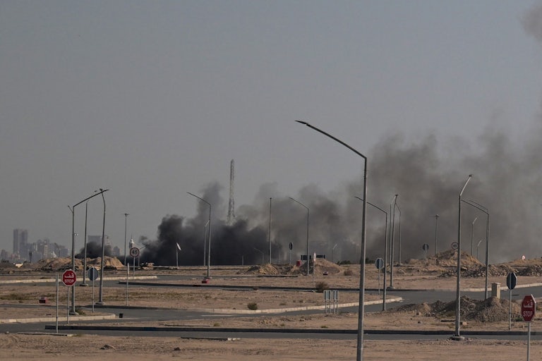 Smoke rises in the background in a photo in Kuwait City.