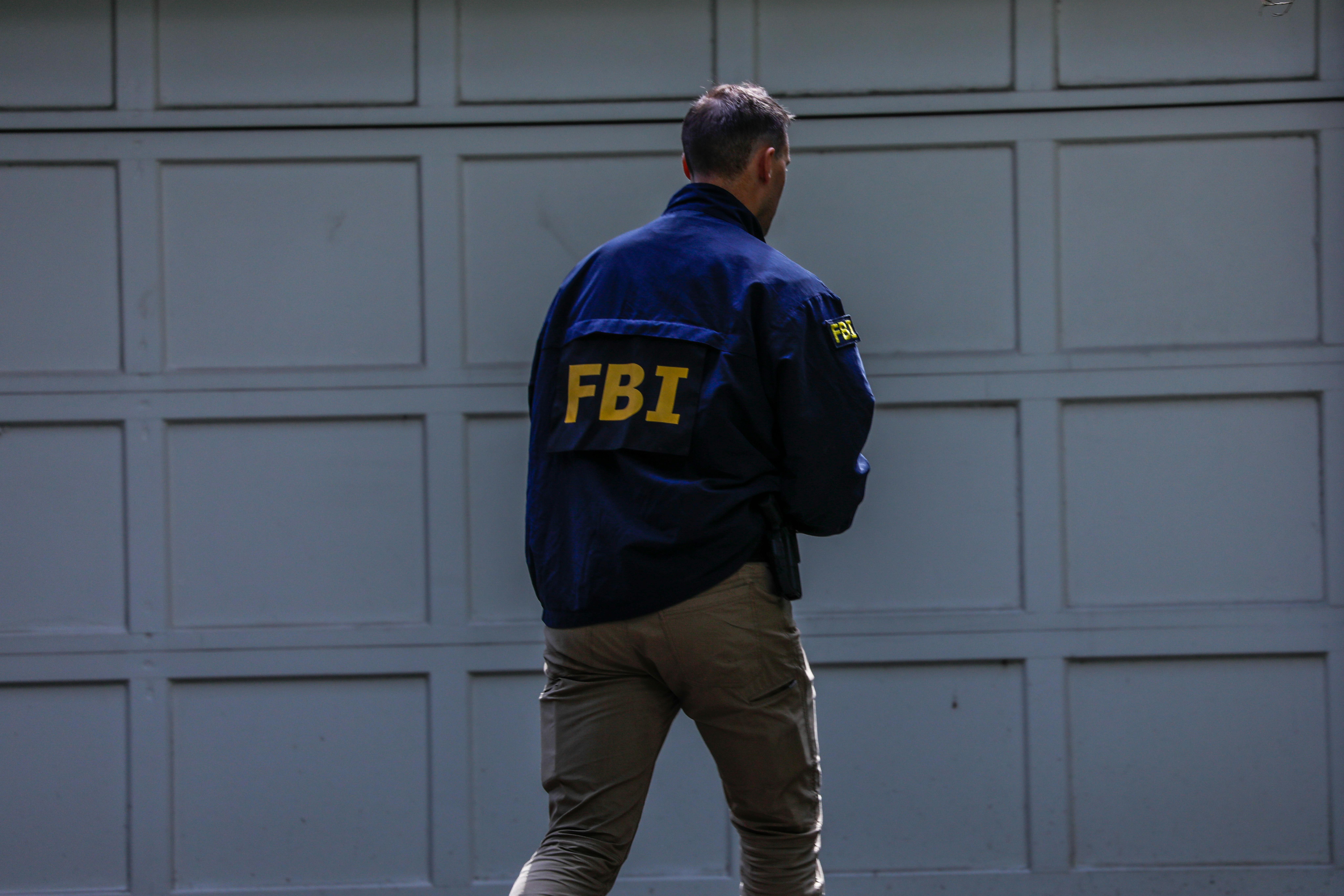 An FBI agents walks near a garage.