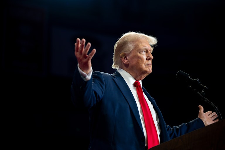 Donald Trump holds his arms up during a campaign event