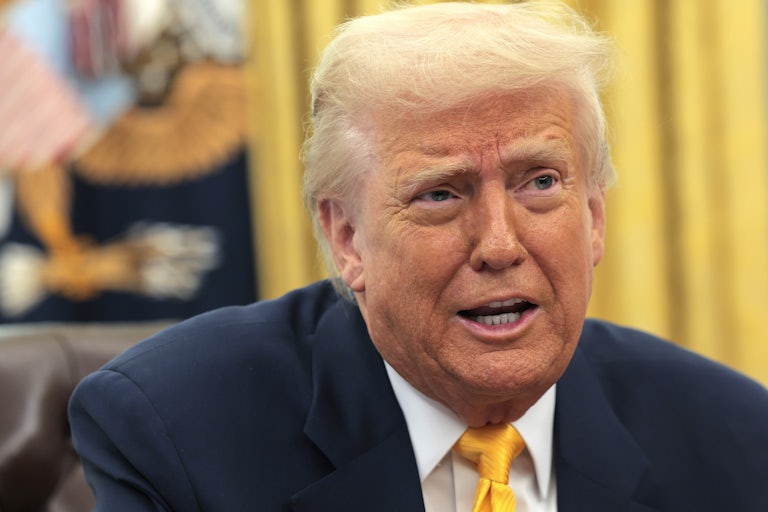 Donald Trump speaks to reporters while seated in the Oval Office
