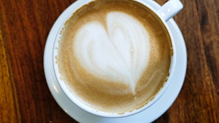 A cup of coffee with a heart design in foam