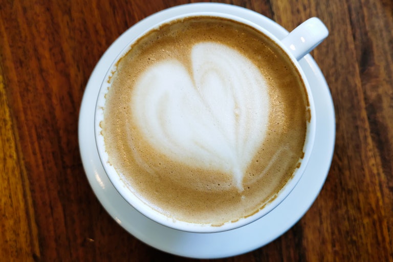 A cup of coffee with a heart design in foam