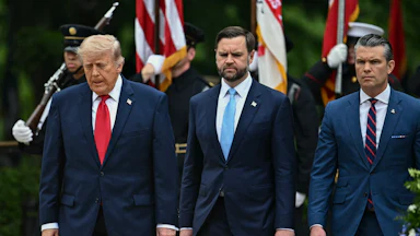 President Donald Trump, Vice President JD Vance, and Defense Secretary Pete Hegseth stand side by side, looking down.