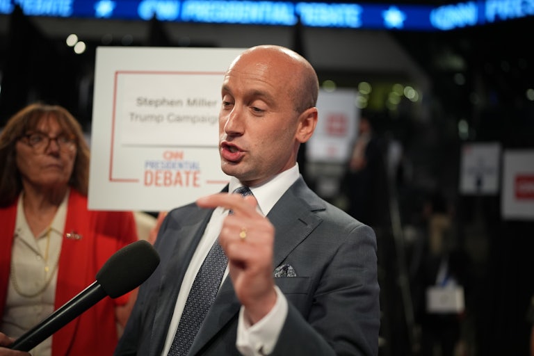 Stephen Miller, who is bald—really bald!—makes a silly face and kind of closes his eyes as he points.