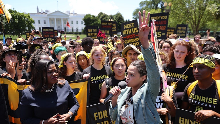 Cori Bush and Alexandria Ocasio-Cortez stand with protesters in front of the White House.