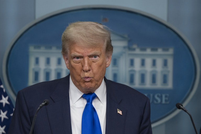 Donald Trump purses his lips while addressing reporters in the White House briefing room