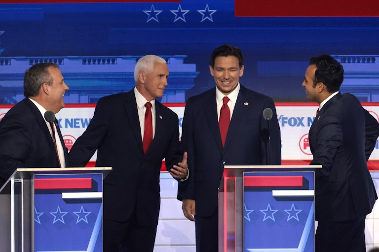 Republican presidential candidates Chris Christie, Mike Pence, Ron DeSantis, and Vivek Ramaswamy share a laught together behind their lecterns at a recent debate.