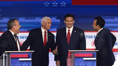 Republican presidential candidates Chris Christie, Mike Pence, Ron DeSantis, and Vivek Ramaswamy share a laught together behind their lecterns at a recent debate.
