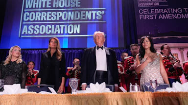 White House press secretary Karoline Leavitt, First Lady Melania Trump, President Donald Trump, and Weijia Jiang, White House Correspondents’ Association president and CBS Senior White House Correspondent, stand in a line at a table during the White House Correspondents’ Association dinner.
