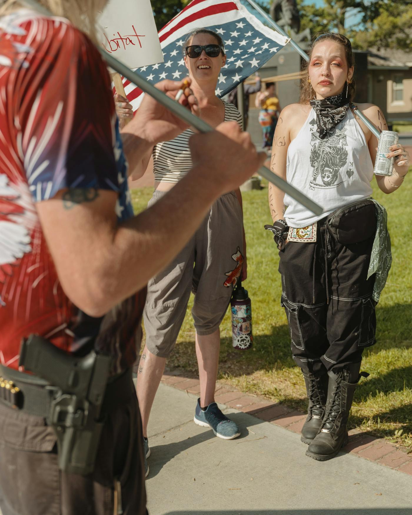Two demonstrators look on while an armed right-wing counterprotester attempts to provoke a reaction during the No Kings rally in Kalispell, Montana, on June 14.