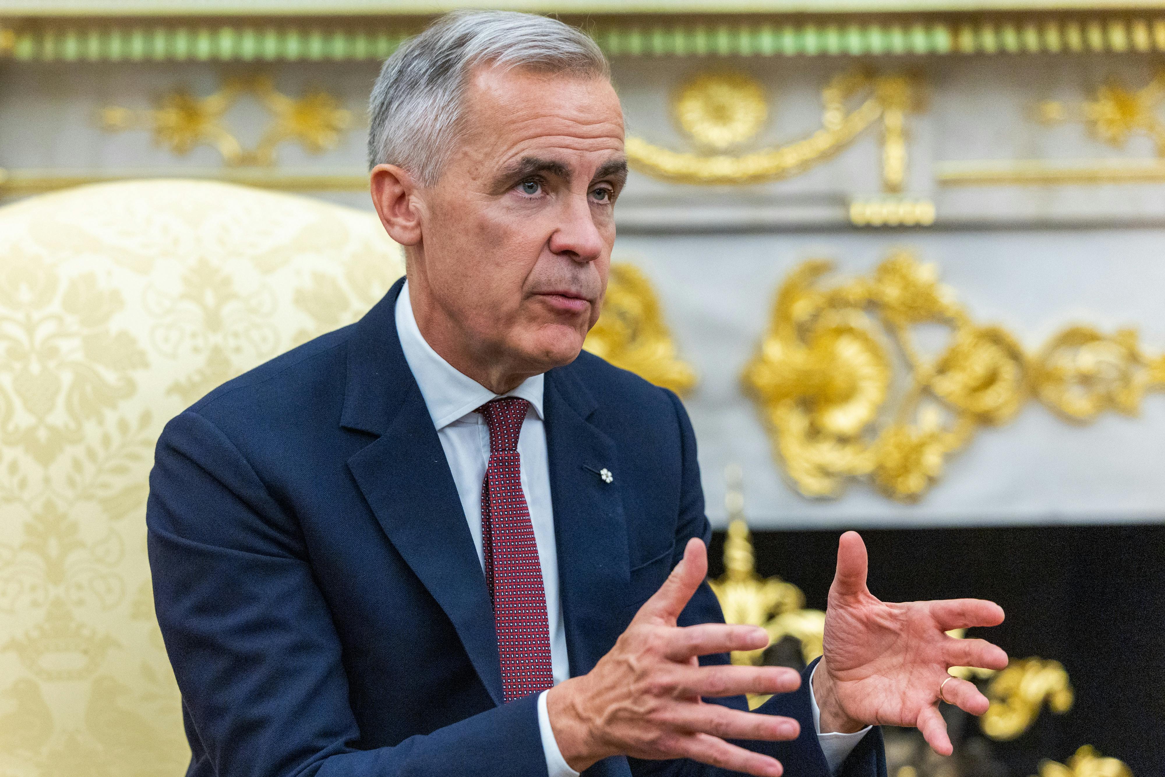 Canadian Prime Minister Mark Carney gestures and speaks while sitting in the Oval Office