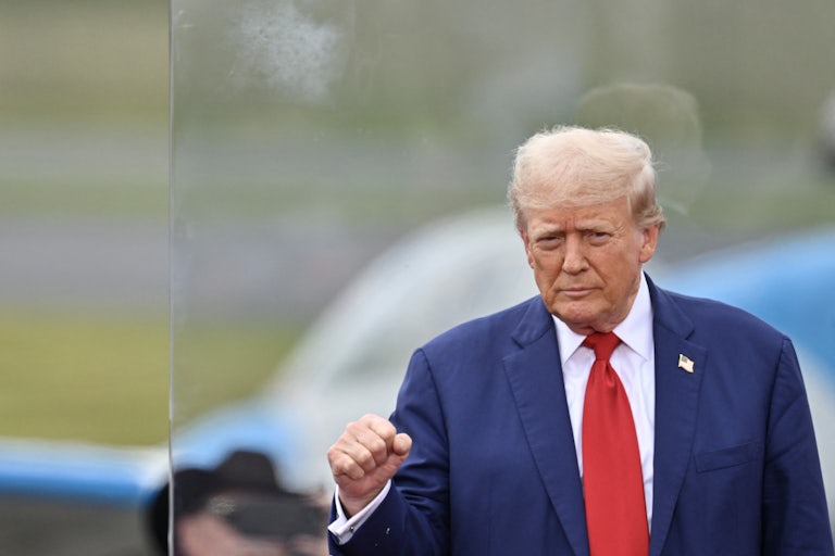 Donald Trump holds up his fist during a campaign event