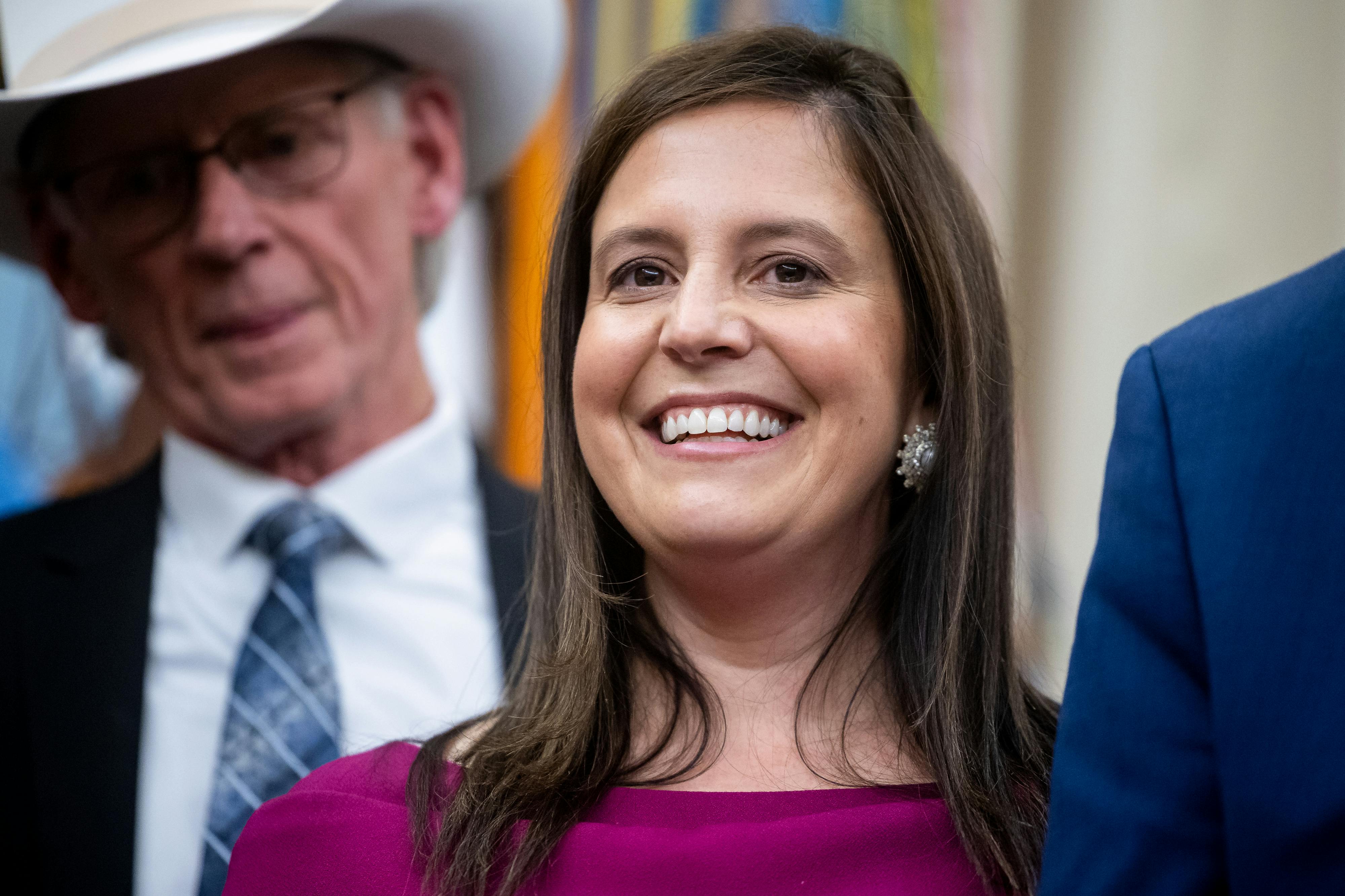 Representative Elise Stefanik smiles while standing in the Oval Office