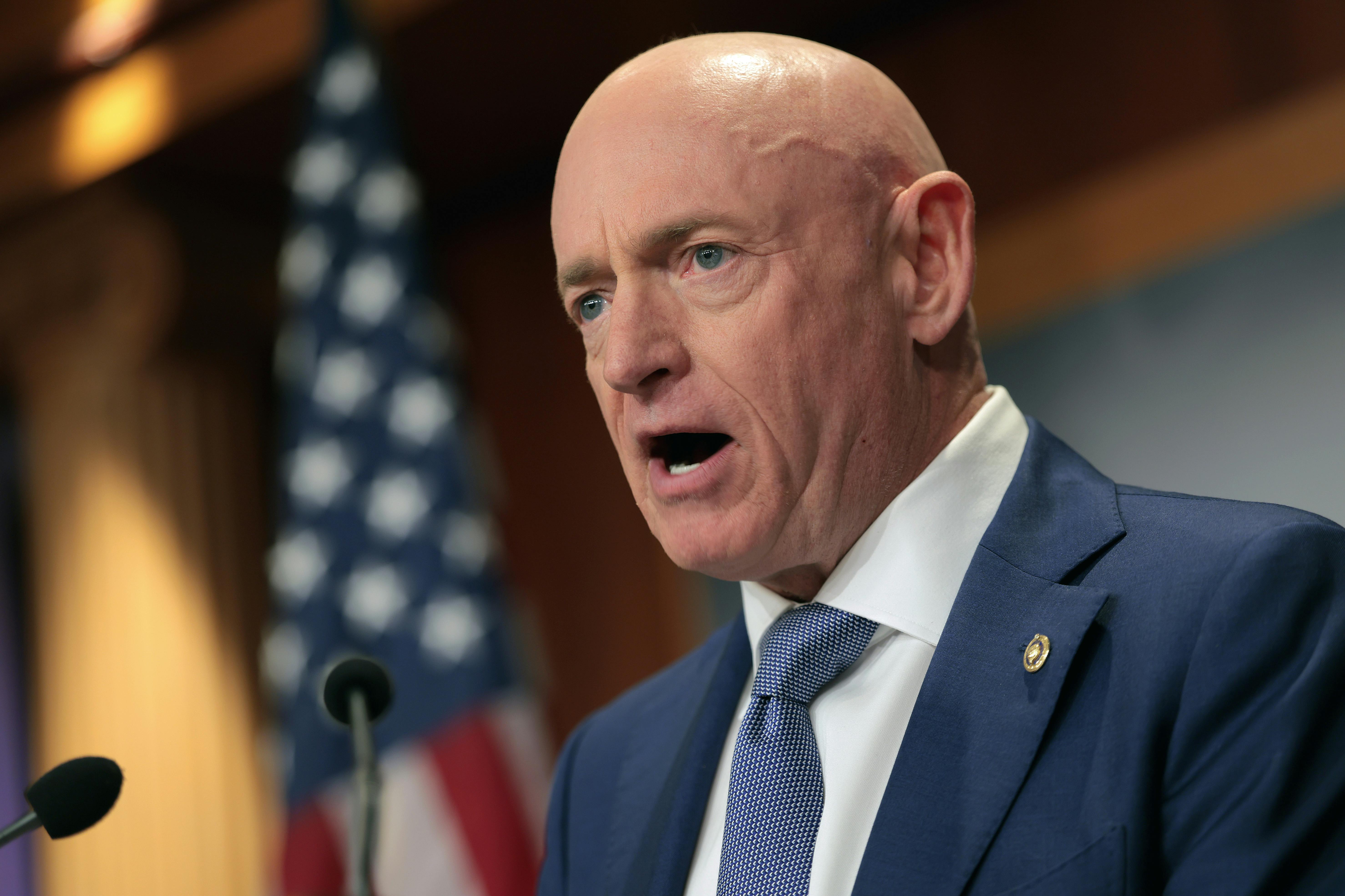 Senator Mark Kelly speaks into a microphone