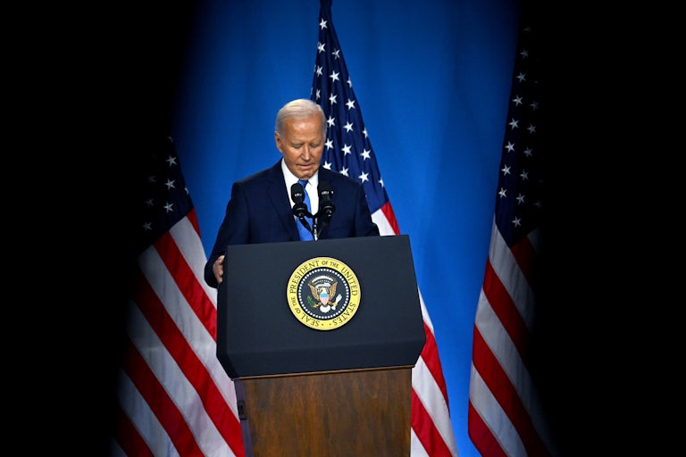 Joe Biden looks down at the podium during a press conference