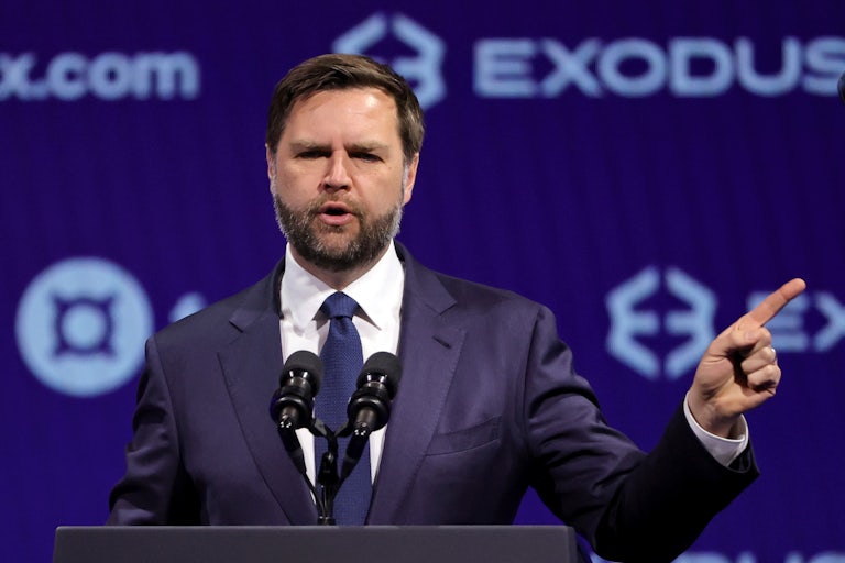 JD Vance speaks at a podium at a crypto conference.