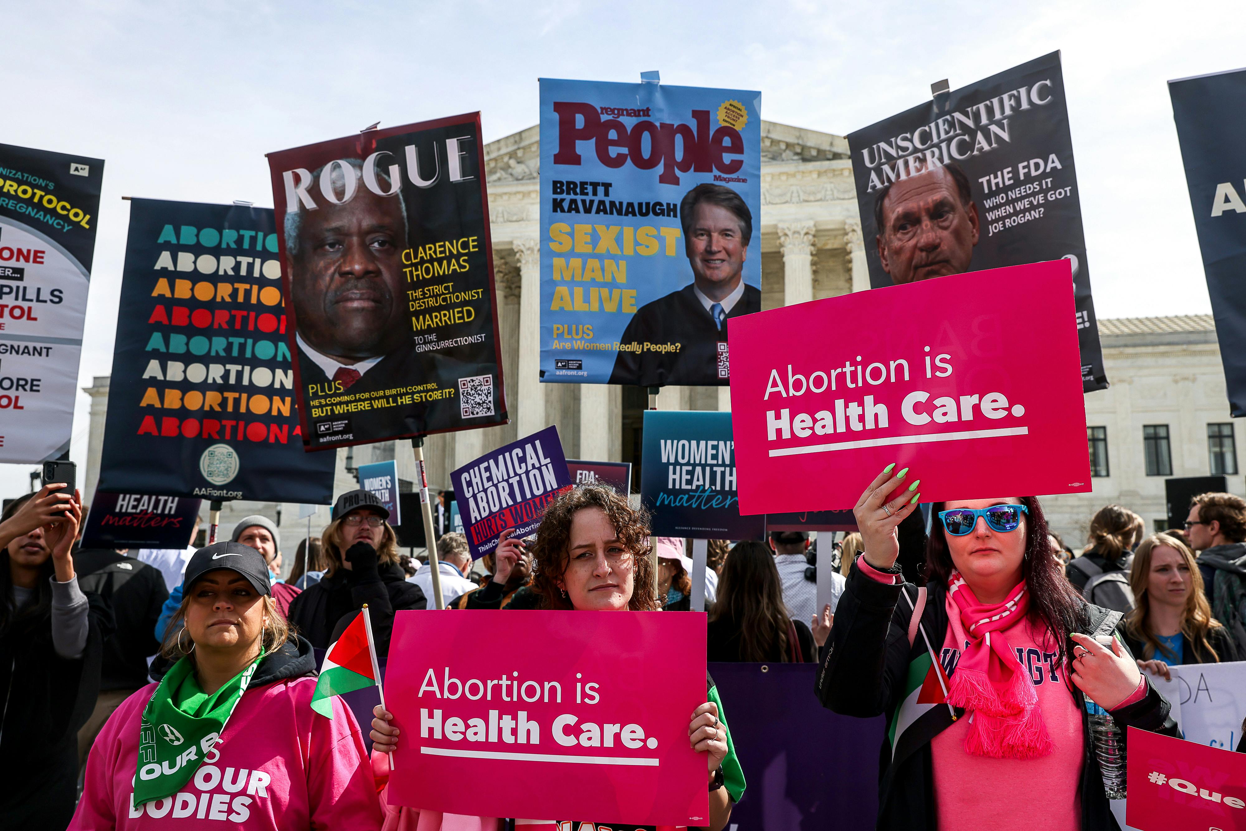 Demonstrators hold pro-choice signs.