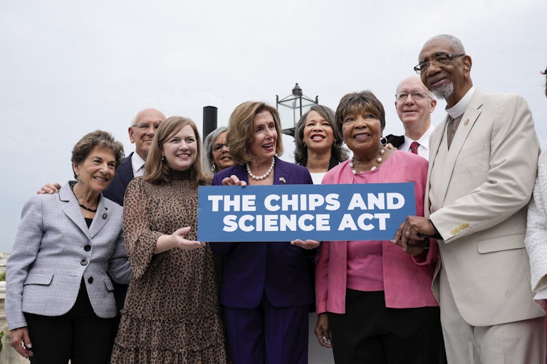 Nancy Pelosi and other members of Congress hold a sign celebrating the CHIPS Act.