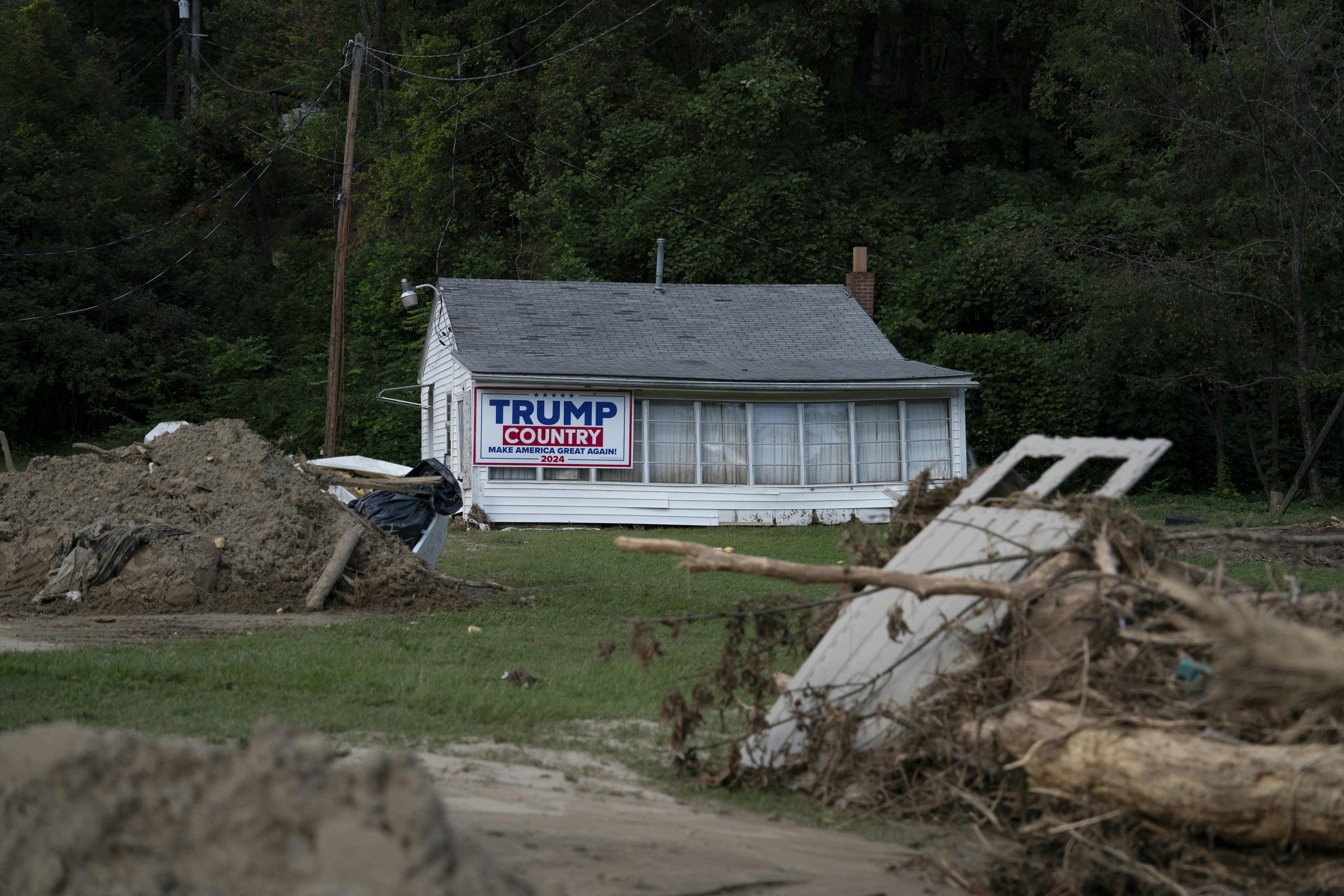 Debris is seen in front of a home with a Trump 2024 campaign sign in Lake Lure, North Carolina, October 2, 2024, after Hurricane Helene.