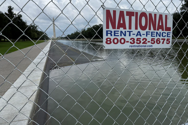 A fence surrounds the drained Reflecting Pool.