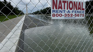 A fence surrounds the drained Reflecting Pool.