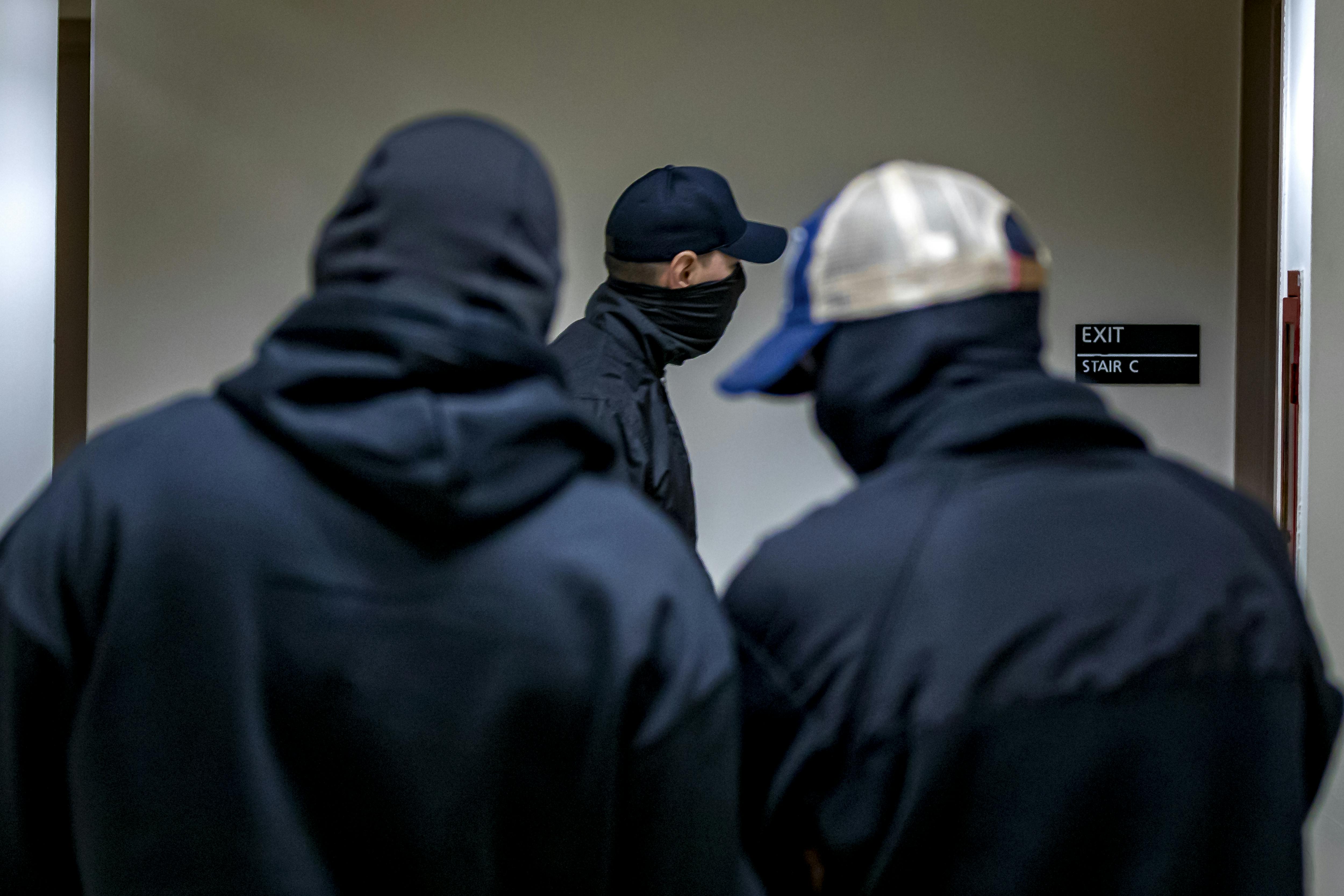 Three masked plainclothes ICE agents