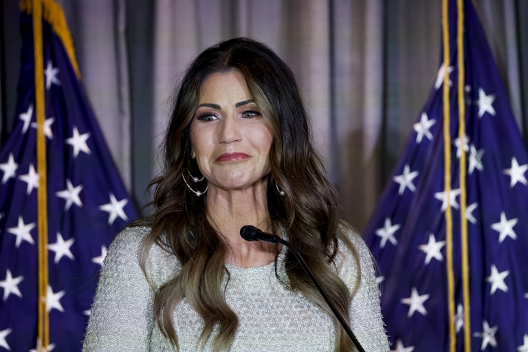 Kristi Noem stands in front of a microphone
