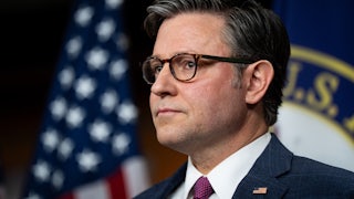 House Speaker Mike Johnson stands during a press conference